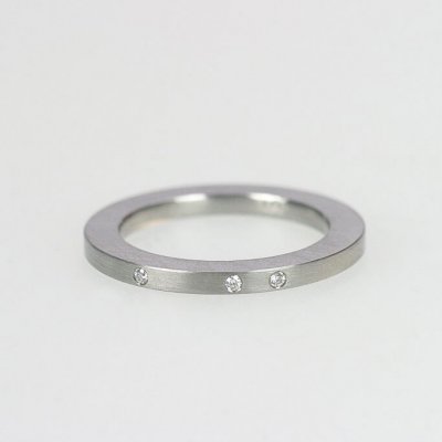 Ring in Edelstahl, 2mm breit, 3 Brillanten à 0,01ct, unregelmäßig gefasst. mattierte Oberfläche